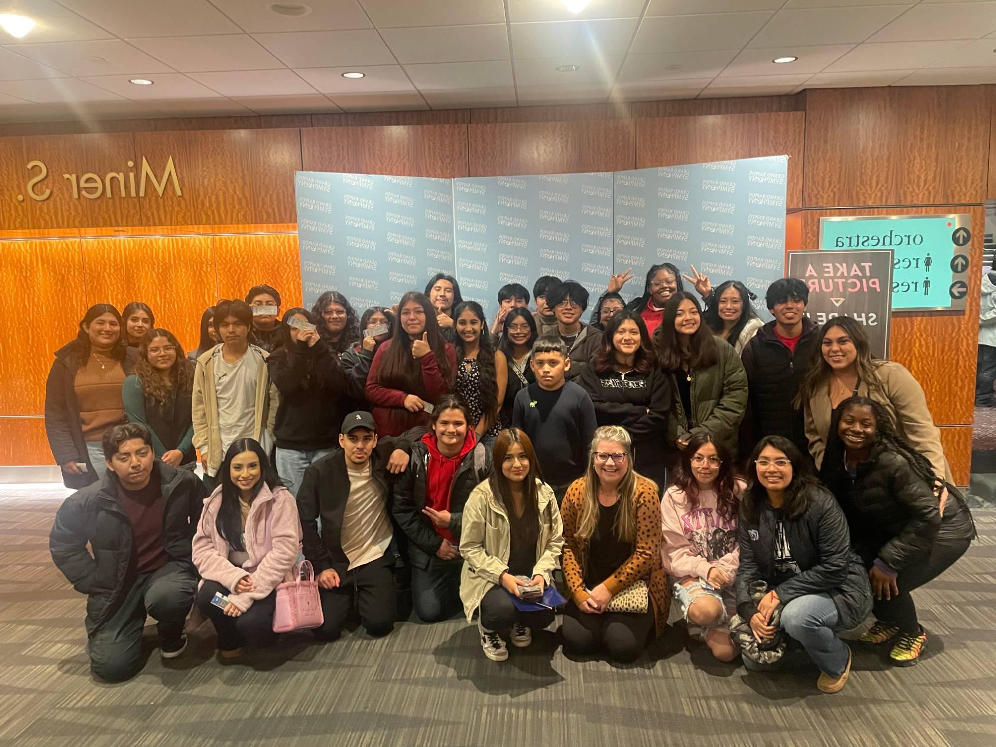 A group of students in front of a Grand Rapids Symphony backdrop